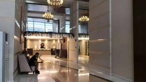 a woman sitting in a chair in a lobby at Dreamy Sunset Bay in Manila