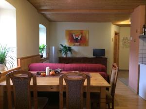 a dining room with a table and a couch at Jörgs Ferienwohnung Lohmen in Lohmen +11 photos