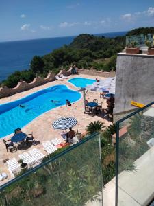 a view of a swimming pool with chairs and the ocean at Hotel Diana in Ustica