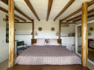 sypialnia z dużym łóżkiem i drewnianym sufitem w obiekcie Casa Estrela w mieście Loulé