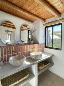 two sinks in a bathroom with two mirrors at Casa Estrela in Loulé