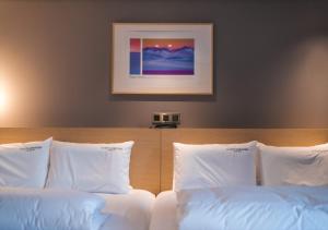 um quarto com 2 camas e almofadas brancas em Nampo Ocean2Heaven Hotel& Spa em Busan