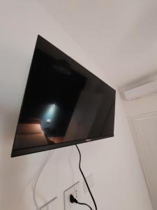 einen Flachbild-TV, der an einer Wand hängt in der Unterkunft Studio Donatello in Mailand