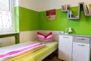 ein Kinderzimmer mit grünen Wänden und einem Bett in der Unterkunft NEU! Reiterhof Finkenmühle Fewo Wicky mit Balkon in Weißenstadt