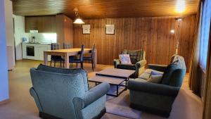 a living room with chairs and a table and a kitchen at Tgèsa Val in Sedrun