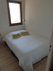 a bedroom with a white bed with a window at Appartement T3 50m² - 6 pers. - Barcelonnette in Barcelonnette