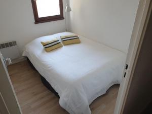 a white bed with two pillows on top of it at Appartement T3 50m² - 6 pers. - Barcelonnette in Barcelonnette