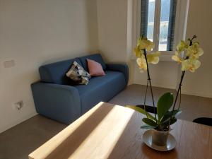 ein blaues Sofa im Wohnzimmer mit einem Tisch in der Unterkunft Studio Donatello in Mailand