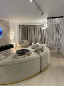 Apartament Luxury Promenada في كرايوفا: غرفة معيشة مع أريكة بيضاء وطاولة