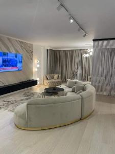 Apartament Luxury Promenada في كرايوفا: غرفة معيشة مع أريكة بيضاء كبيرة في غرفة