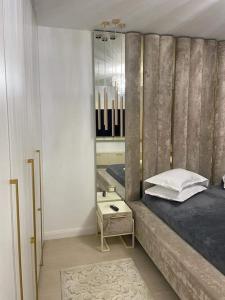 Apartament Luxury Promenada في كرايوفا: غرفة نوم مع سرير ومرآة على الحائط