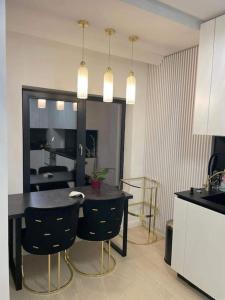 Apartament Luxury Promenada في كرايوفا: مطبخ مع طاولة وكراسي في غرفة