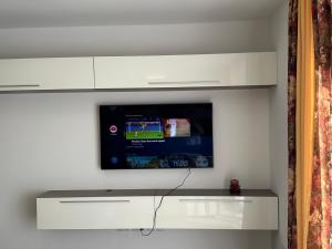 Elle comprend une télévision à écran plat suspendue sur un mur blanc. dans l'établissement New, airy and spacious apartment in Mellieha, à Mellieħa