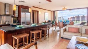 a kitchen with a bar and a living room with a view at Ko Olina Beach Villas O1111 in Kapolei