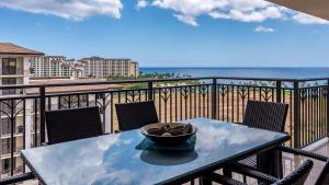 a table on a balcony with a view of the ocean at Ko Olina Beach Villas O1111 in Kapolei
