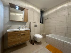 La salle de bains est pourvue de toilettes, d'un lavabo et d'une baignoire. dans l'établissement New, airy and spacious apartment in Mellieha, à Mellieħa