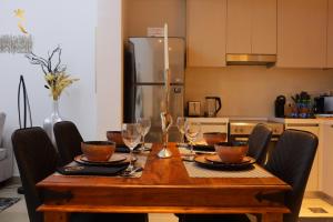 a dining room table with chairs and a table with wine glasses at Twilight 1BR apartment Yas Island in Abu Dhabi