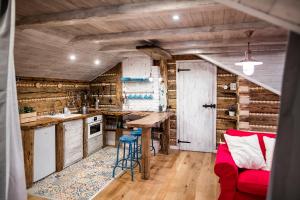 cocina con paredes de madera y sofá rojo en Apartmán Nebe, en Dolní Lomná