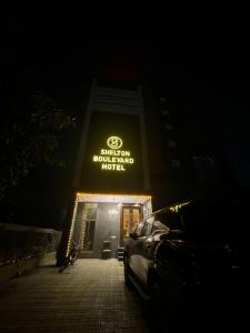 een gebouw met een bord waarop staat: een geleend hotel met buchanan bij Shelton Boulevard Hotel Lahore in Lahore