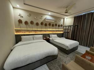 a hotel room with two beds in a room at Shelton Boulevard Hotel Lahore in Lahore