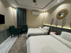 Postel nebo postele na pokoji v ubytování Shelton Boulevard Hotel Lahore