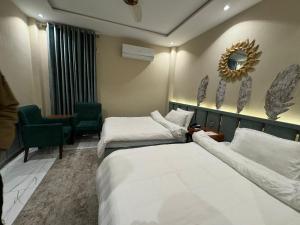 Postel nebo postele na pokoji v ubytování Shelton Boulevard Hotel Lahore