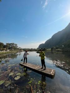 dwoje ludzi stojących na tratwie w rzece w obiekcie Chez Beo Homestay w mieście Ninh Binh