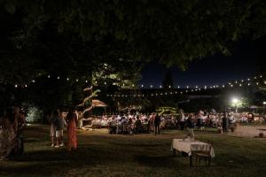a crowd of people in a park at night at Villa Il Padule in Bagno a Ripoli