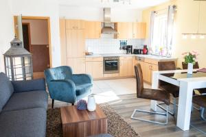 a kitchen and living room with a couch and chairs at Apartment Ohragrund in Oberhof