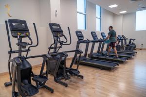 a man walking on a treadmill in a gym at Twilight 1BR apartment Yas Island in Abu Dhabi