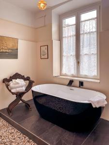 eine große Badewanne im Bad mit Fenster in der Unterkunft Villa Gelsomino Exclusive House in Santa Margherita Ligure