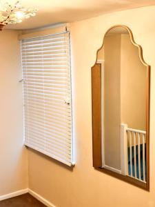 ポーツマスにある6 Centrale Portsmouthの鏡と窓(窓ブラインド付)が備わる客室です。