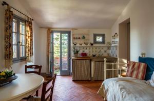 a kitchen and living room with a table and a bed at Casa Ezio Marchi - Tre spaziose suite in Bettolle