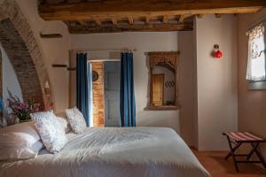 a bedroom with a large bed with blue curtains at Casa Ezio Marchi - Tre spaziose suite in Bettolle
