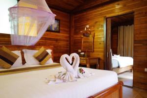 two swans sitting on a bed in a bedroom at Anda Lipe Resort in Ko Lipe