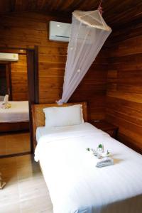 a bedroom with a bed with a net on it at Anda Lipe Resort in Ko Lipe