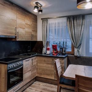 a kitchen with wooden cabinets and a table with a tableablish at Bergler Hoamat 5 - 8 Personen in Navis