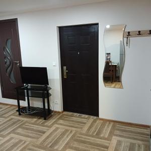 um quarto com uma porta preta e um espelho em Дом для гостей em Guiumri