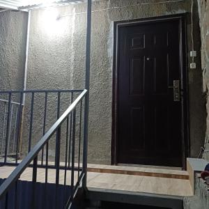 uma porta preta no lado de um edifício em Дом для гостей em Guiumri