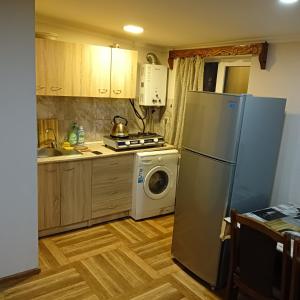 uma cozinha com um frigorífico e uma máquina de lavar roupa em Дом для гостей em Guiumri
