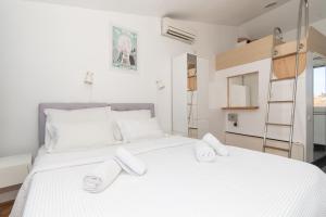 a bedroom with a large white bed with towels on it at Rooms Gold in Split