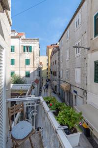 a balcony with a chair and plants on a building at Rooms Gold in Split