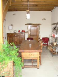 a dining room with a wooden table and chairs at La Grange du Bourg in Deneuille-les-Mines