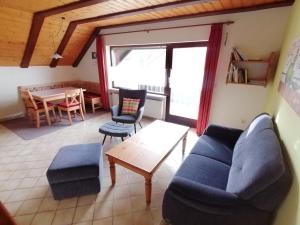 ein Wohnzimmer mit einem Sofa und einem Tisch in der Unterkunft Ferienhaus Herzog in Haundorf