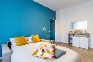 a bedroom with a blue wall and a bed with yellow pillows at [Arona Centro] Blue Lake - Wi-Fi in Arona