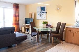 a living room with a dining room table and chairs at Haus Ohragrund in Oberhof