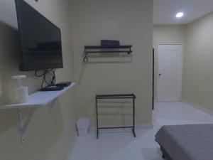 Elle comprend un salon avec une télévision et un bureau avec un ordinateur. dans l'établissement NURUL ROOMSTAY LANGKAWI, à Pantai Cenang