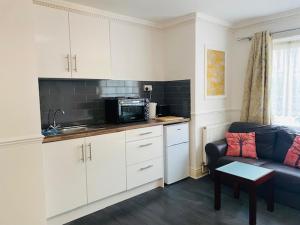 a living room with a couch and a kitchen at Circle Guest House Bed Only in Southampton