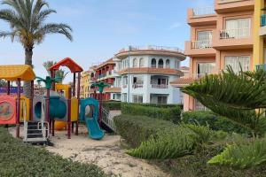 un parque infantil frente a un edificio de apartamentos en Porto Matrouh unique Chalet en Marsa Matruh