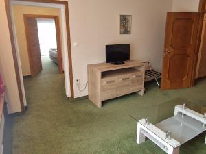 a living room with a tv and a cabinet with a television at Kolmhof in Bad Kleinkirchheim